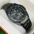 Black wristwatch with detailed face in a box on grass
