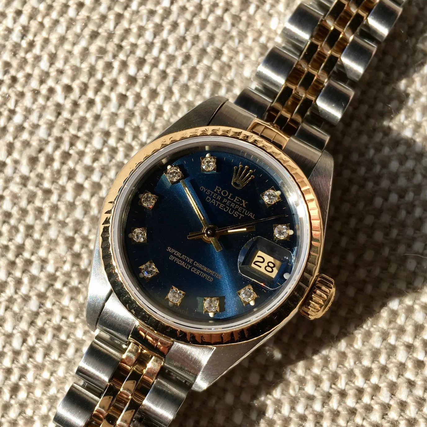 Luxury watch with blue face and gold accents on a textured surface